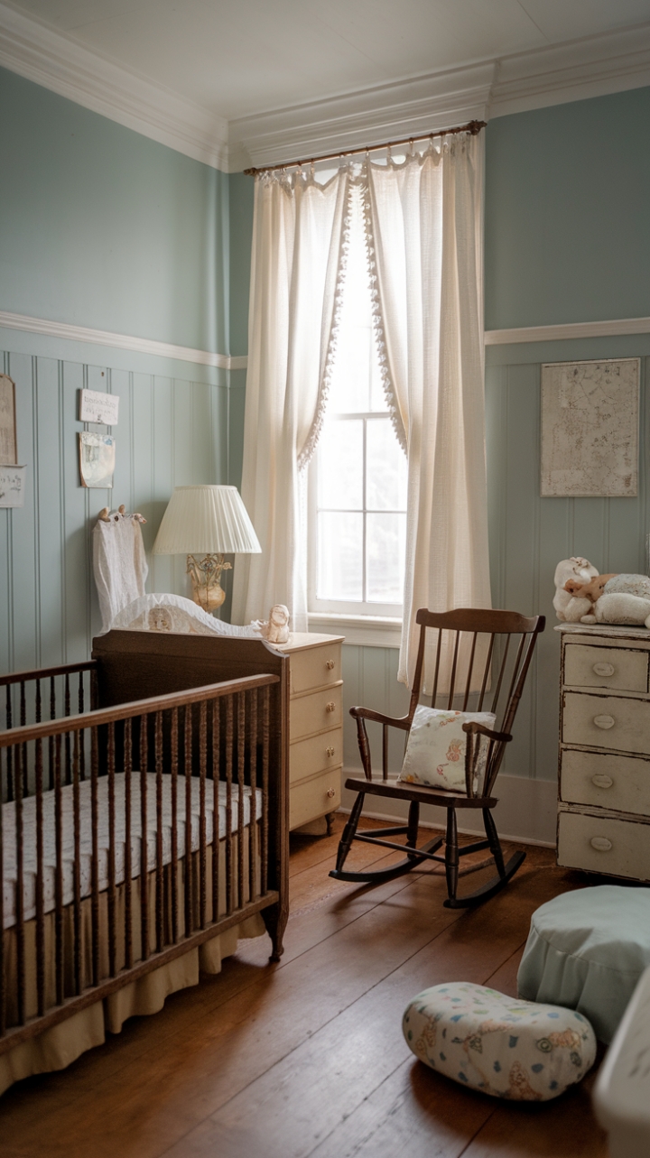 A charming vintage nursery exudes timeless appeal with its soft blue walls and delicate white trim, creating a serene haven for a little one. Antique baby furniture, including a beautifully crafted wooden crib and a cozy rocking chair, adds nostalgic warmth to the space. A classic dresser with charming drawers offers practical storage, while a gentle lamp beside the crib casts a soothing glow. The window, adorned with flowing white curtains, bathes the room in natural light, highlighting the warm wooden floor. Soft toys nestled near the crib evoke a sense of innocence and comfort, completing this shabby chic retreat that beautifully blends vintage charm with cozy elegance.